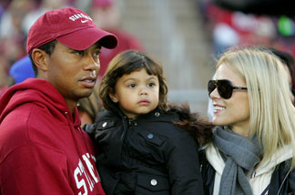 Honorary Stanford Cardinal captain Tiger Woods holds his daughter, Sam, and speaks to his wife, Elin Nordegren, on the sidelines before the Cardinal game against the California Bears at Stanford Stadium on November 21, 2009 in Palo Alto.