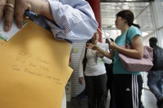 A man waits in a long line to turn in his federal and state tax forms on April 18, 2011, at a U.S. Post Office in San Jose.