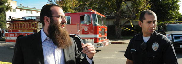 Rabbi Nachman Abend (L) waits for information outside police lines near the Adat Yeshurun Sephardic Congregation where two Jewish men were shot and injured, in Los Angeles on October 29, 2009. The two men were wounded at the Los Angeles synagogue in what police said was being investigated as a possible hate crime. Michel Moore, the deputy chief of Los Angeles police, said the two men were shot in their legs after arriving separately in an underground car park at the Adat Yeshurun Sephardic Congregation in North Hollywood.