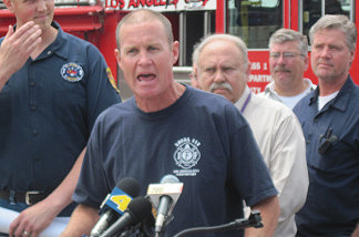 Firefighters and mechanics gather in support as Pat McOsker, the president of the United Firefighters of Los Angeles, speaks at a press conference on May 28, 2010.