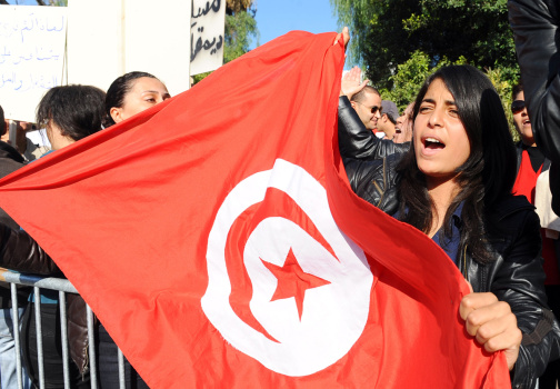 A Tunisian woman holds a flag of Tunisia