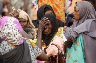 Somali refugees wait at the entrance to the registration area of the IFO refugee camp which makes up part of the giant Dadaab refugee settlement on July 24, 2011 in Dadaab, Kenya.