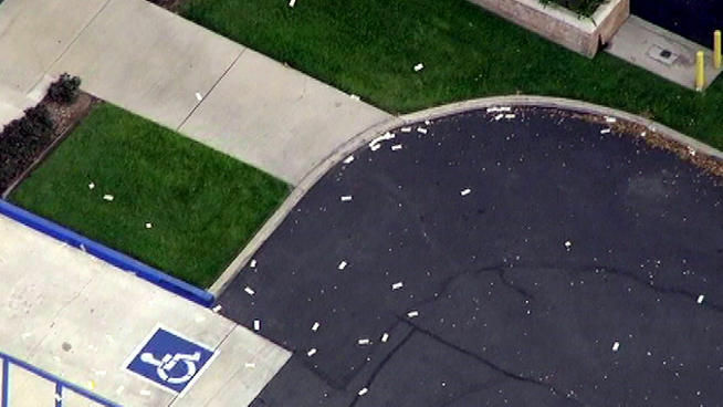 Money scattered on the ground outside a Chino bank.