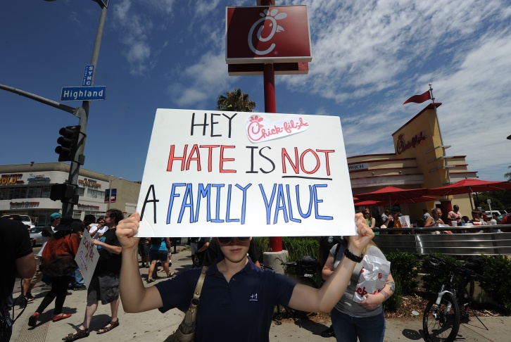 An anti-Chick-fil-A protestor holds a si