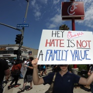 An anti-Chick-fil-A protestor holds a si