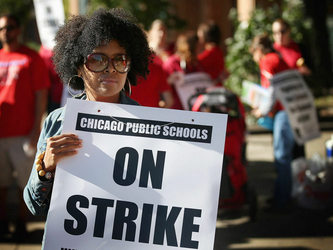 Chicago public school teachers picket outside William H.Wells Community High School on Monday.
