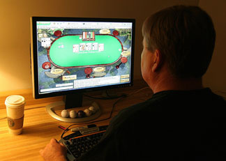 A man plays poker on his computer connected to an internet gaming site from his home in Manassas, VA 02 October, 2006.