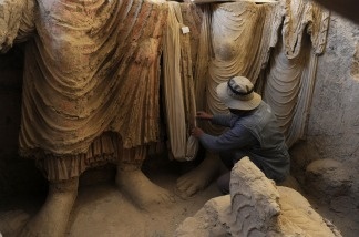 An Afghan archaeologist looks at the remains of Buddha statues discovered inside an ancient monastery in Mes Aynak, in the eastern province of Logar on November 23, 2010.