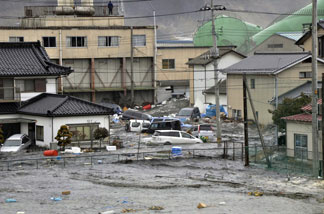 A tsunami, tidal wave smashes vehicles and houses at Kesennuma city in Miyagi prefecture, northern Japan on March 11, 2011.