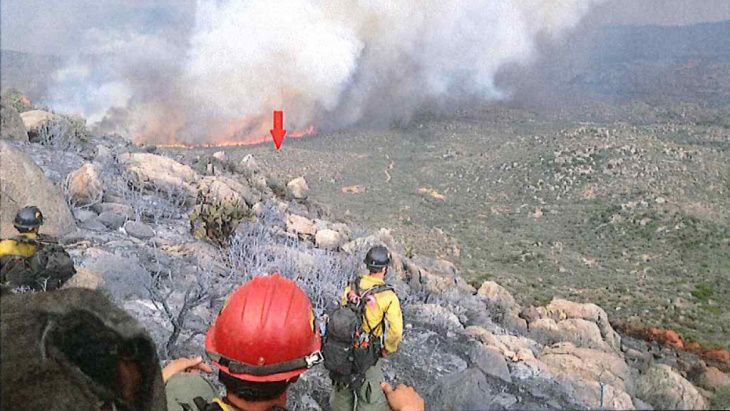 A photo taken by the Granite Mountain Hotshots on June 30 shows their position on a ridge, with a red arrow indicating the original location of their lookout. The crew's lookout was the only team member to survive the fire.