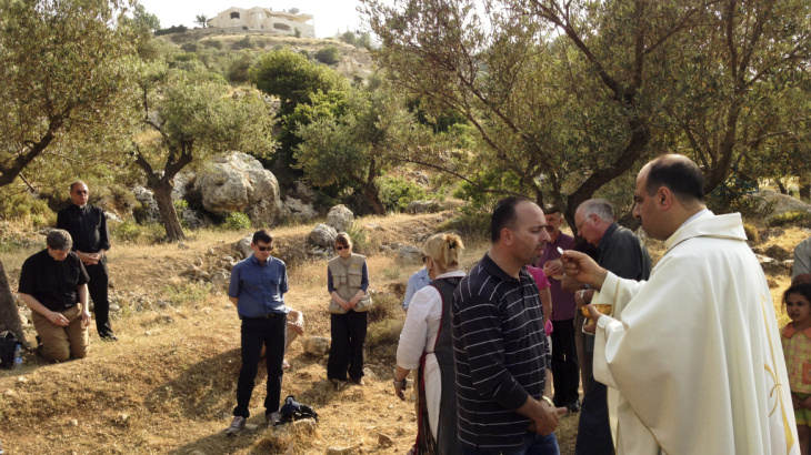 Ibrahim Shomali, a Palestinian priest, offers Communion under the olive trees of the Cremisan Valley in the Israeli-occupied West Bank. This is part of a regular protest against Israeli plans to build a section of its West Bank barrier here, which would s