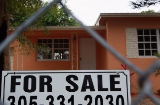 A for sale sign stands in front of a home in Miami, Florida. A measure of Americans who signed contracts to buy homes increased last month to its highest level in two and a half years, the latest sign of improvement in the once-battered housing market.