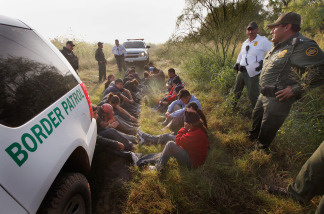 Border Patrol agents detain undocumented immigrants apprehended near the Mexican border on May 28, 2010 near McAllen, Texas.