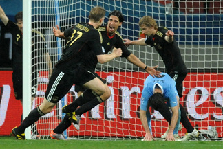 Germany's midfielder Sami Khedira (2nd left) celebrates his goal with teammates defender Per Mertesacker (L) and striker Stefan Kiessling (rear) while Uruguay's defender Diego Godin falls during the World Cup third-place soccer match between Germany and Uruguay at Nelson Mandela Bay Stadium in Port Elizabeth, South Africa on Saturday. Germany won 3-2.