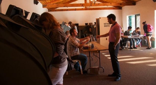 Allan Hull, clerk, gives Vladimir Gulkarov his code to vote at the George G. Golleher Alumni House during the 2012 presidential elections at Cal State University, Fullerton in Fullerton, Calif., Tuesday, November 6, 2012. Local residents were given a chance to vote at the polling location at the university campus.