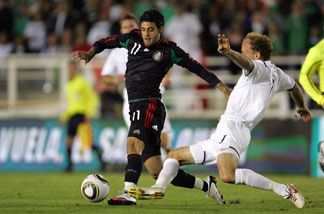 Carlos Vela #11 of Mexico plays the ball as Simon Elliott #7 of New Zealand slides in for the tackle in the second half during their International Friendly match at the Rose Bowl on March 3, 2010 in Pasadena.
