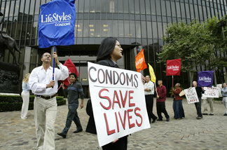 Protesters holding banners that look like giant condoms call on pornography executive Larry Flynt to voluntarily adopt a 100% condom use policy in his sexually explicit films, during a demonstration by the AIDS Healthcare Foundation outside the Flynt Publications building on June 7, 2004 in Los Angeles, California.
