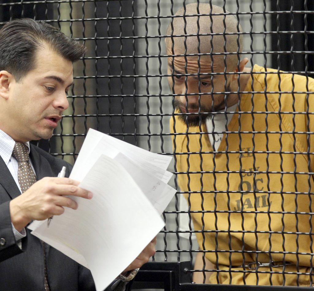 In this file photo, defendant Itzcoatl Ocampo confers with attorney Randall Longwith during Ocampo's arraignment Tuesday Feb. 21, 2012 in Santa Ana, Calif. Ocampo, a former Marine, was charged with the murder of six people in Southern California, including four homeless men and a friend's mother and brother. Attorney Michael Molfetta said Friday that Ocampo died in custody after ingesting Ajax.