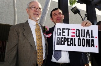 Same-sex couple Nowlin Haltom and Michael McKeon hold as sign calling for the right to marry outside the County Clerk's Office in Los Angeles on Valentine's Day, February 14, 2011.