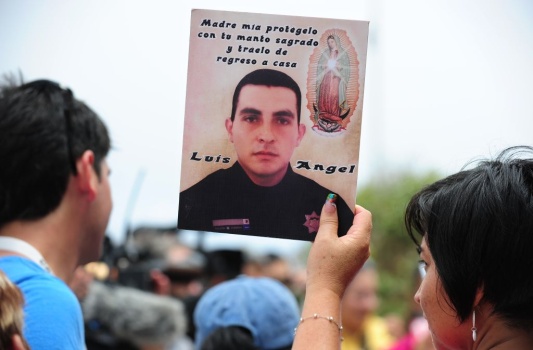 A woman holds a portrait of a deceased o