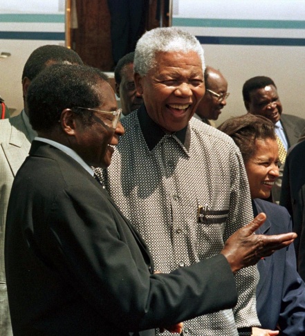 Zimbabwe's President Robert Mugabe, left, greets South African President Nelson Mandela in Harare, Zimbabwe, in 1998. The two men have shaped their countries in dramatically different ways.