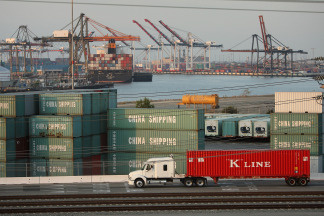 A truck passes shipping containers at China Shipping at the Ports of Long Beach and Los Angeles, the busiest port complex in the US, on September near Long Beach, California.