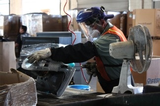 A worker at E-Recycling of California in Paramount breaks down an old computer.