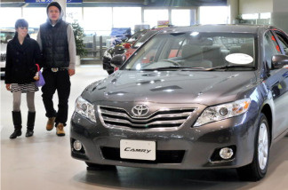 Customers check a Toyota Camry at the company's showroom in Tokyo on January 27, 2010.