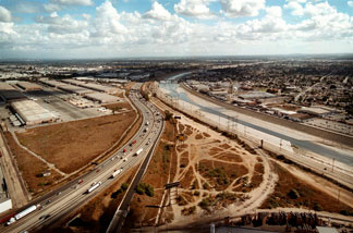 File photo: The cement-confined Los Angeles River, right, slides past open industrial lots in the Los Angeles, CA community of Maywood, November, 2000.