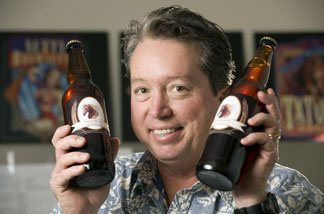 Cal Poly Pomona professor Owen Williams with bottles of Bronco Brown brewed with the help of university students