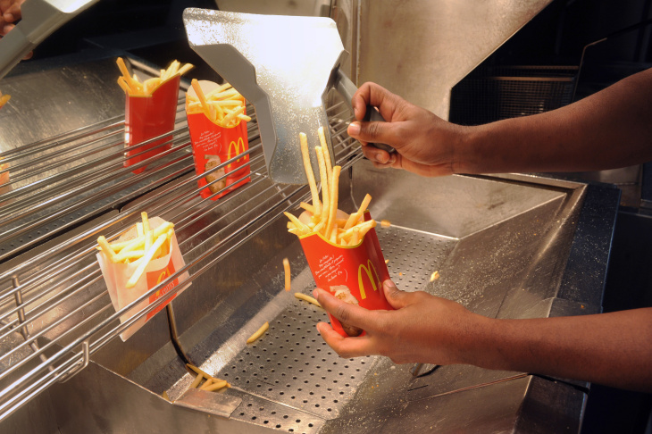 An employee serves French fries at a US