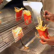 An employee serves French fries at a US