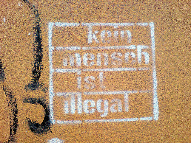 A sign reading "no person is illegal" in German. In the U.S., the debate over whether to use "illegal immigrant" to describe a person in the country without permission took a sharp turn this week when The Associated Press announced it was dropping the term from its media stylebook. But people are still at odds over what term to use.