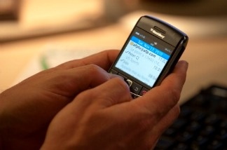 A man checks his email on a Blackberry.