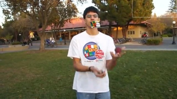 A screen shot of Ravi Fernando juggling and solving a Rubik's Cube.