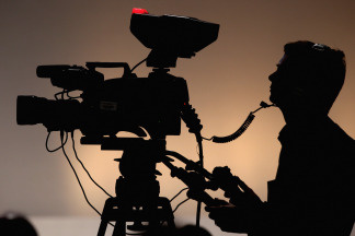 A silhouette of a camera operator shooting film. File photo.
