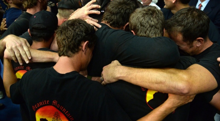 Holding on to each other: Firefighters hug during a memorial service Monday in Prescott, Ariz. They were honoring 19 others who died Sunday.