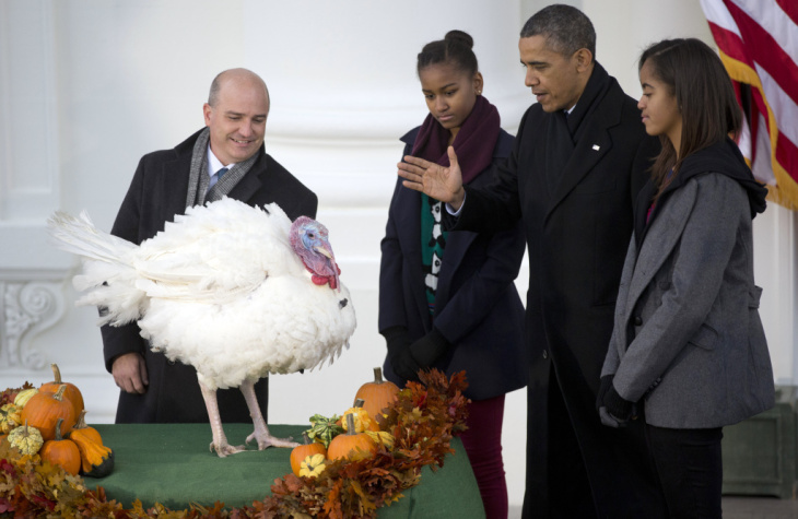 President Barack Obama, with daughters Sasha, second from left, and Malia, right, bestows a presidential pardon on Popcorn, the turkey, in a White House Thanksgiving tradition.