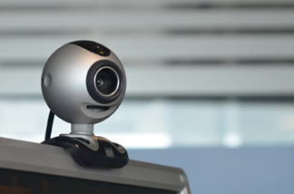 A web cam perched on top of a computer.