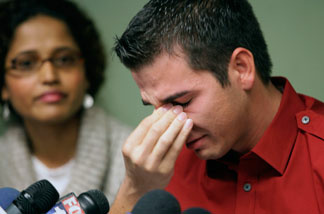 Adult film actor Derrick Burts, 24, who tested positive for HIV, reacts during a news conference, Wednesday, Dec. 8, 2010, in Los Angeles. Burts said he wished he had known more about the risks of contracting sexually transmitted diseases in the industry and is calling for mandatory condom use in porn films. At left is Dr. Shilpa Sayana.