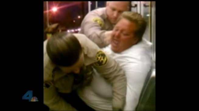 Screenshot via NBC of cellphone footage from the night Army veteran Julie Nelson was being detained by two law enforcement officials. Nelson admits cursing during the altercation, but denies acting out with physical violence.