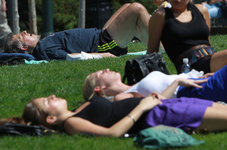 People sunbathe in the warm weather as temperatures climb.