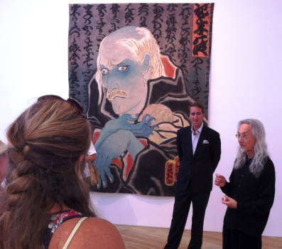 Artist Masami Teraoka explains his AIDS Series painting at Samuel Freeman Gallery as Sam Freeman looks on. 9/11/12.