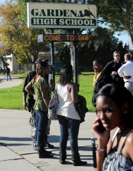 People gather at the entrance to Gardena High School on Jan. 18, 2011 after two students were shot when a gun in a backpack went off in a classroom. The student who brought the gun has been charged with two felony counts.