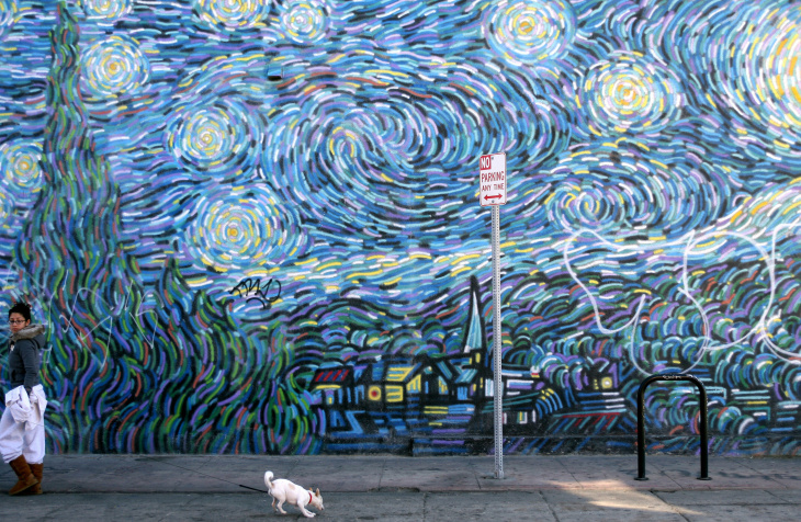 A woman walks in front of a mural in Ven