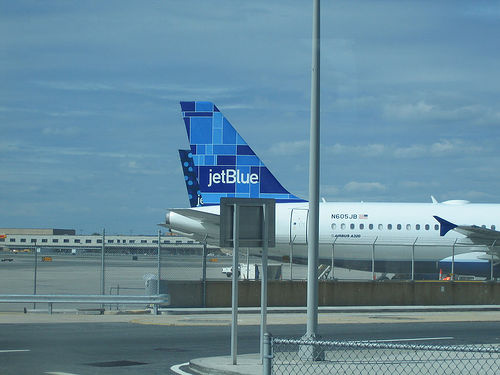 Two JetBlue planes at a gate.