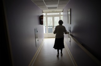 A woman, suffering from Alzheimer's disease, walks in a corridor.