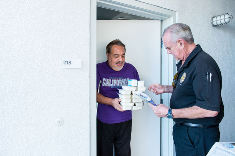 Volunteer Mike Kearin delivers food to client Jesus Barron in November 2016.