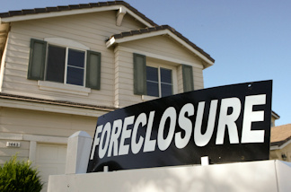 A foreclosure sign sits in front of a home for sale.