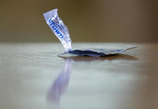 An empty condom package rests on a table during the shooting of a porn scene for the adult film production company Vivid, 18 May 2004, on the set in Canoga Park, California, about 40 miles west of Los Angeles.